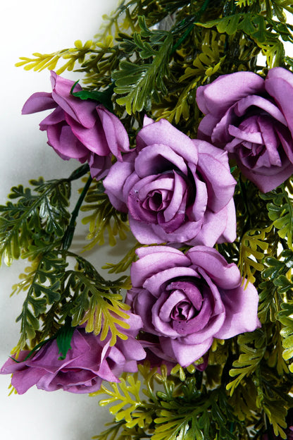 Detalle guirnaldas colgantes artificiales con rosas color lila decorando una estructura con cortinas blancas para boda al aire libre, ideales para eventos, recepciones y montajes florales elegantes.