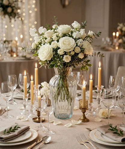 Florero de vidrio Medellín transparente con arreglo de rosas y follaje sobre una mesa en una sala de estilo moderno.
