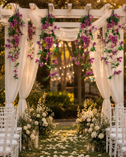 Guirnaldas colgantes artificiales de flores moradas decorando un arco de boda con telas blancas, ideales para ceremonias al aire libre, eventos y decoración floral elegante.
