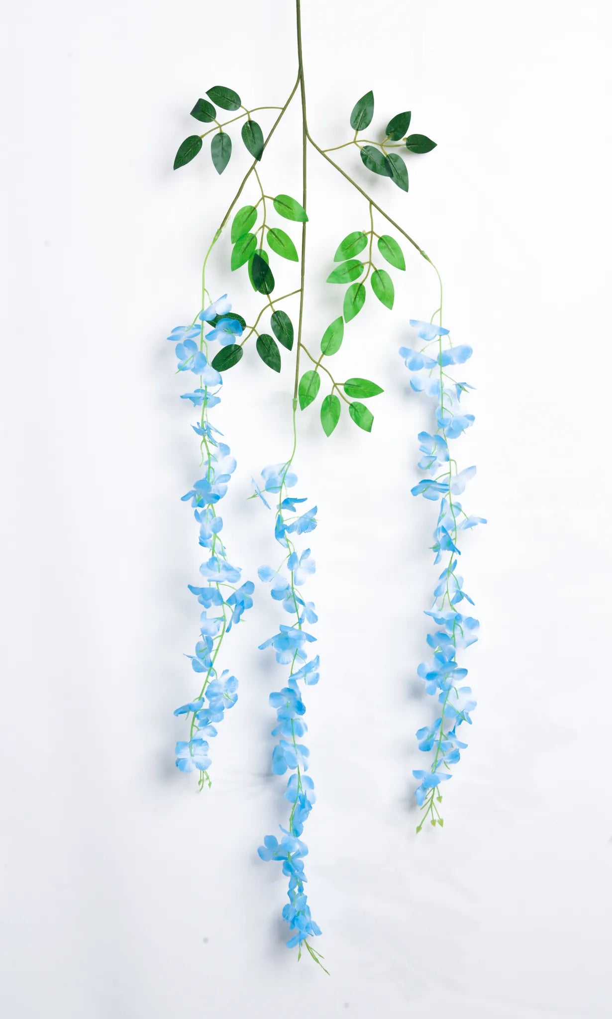 Guirnalda colgante artificial de wisteria azul con hojas verdes y flores en cascada, ideal para decorar bodas, eventos, pérgolas, arcos florales y espacios interiores.