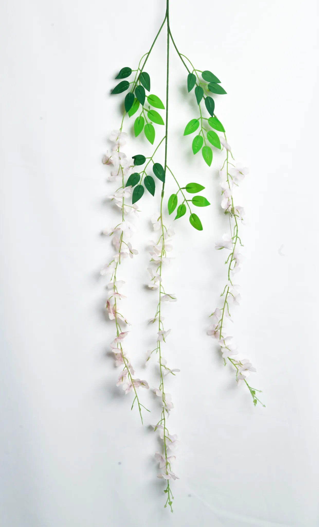 Guirnalda colgante artificial de wisteria rosa claro con hojas verdes y flores en cascada, ideal para decorar bodas, eventos, pérgolas, arcos florales, escaparates y espacios interiores.
